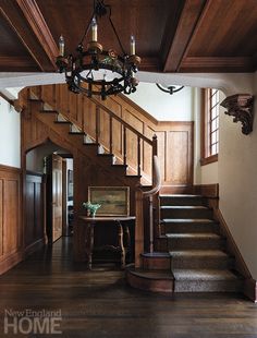 a chandelier hangs from the ceiling above a set of stairs in a house