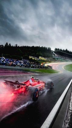 two racing cars on a race track in the rain