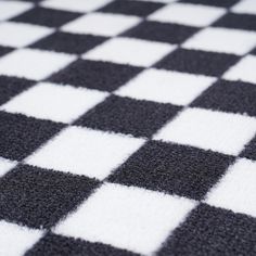 a black and white checkered rug is shown in close up view on the floor