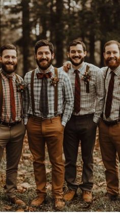 a group of men standing next to each other wearing ties and suspenders in the woods