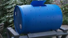 a large blue barrel sitting on top of a wooden bench