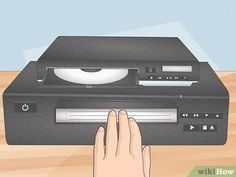 a hand is pressing the button on a record player's turntable step 3