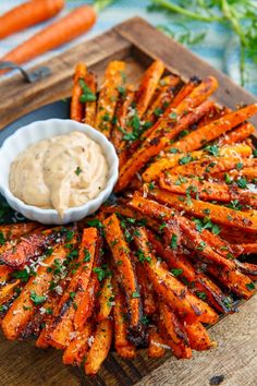 grilled carrots on a platter with dip and parsley garnish