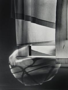 a black and white photo of curtains with shadows on them