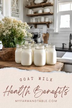 three mason jars filled with milk sitting on top of a kitchen counter next to flowers