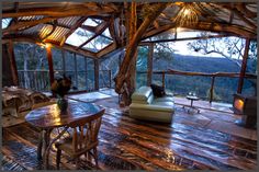 a living room filled with lots of furniture next to a large window covered in wood