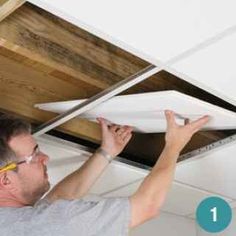 a man is working on the ceiling in his house, and he is fixing it