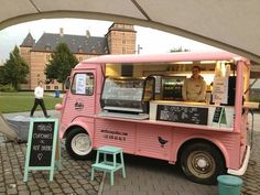 a pink food truck parked in front of a building