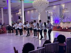 a group of people standing on top of a dance floor in front of a crowd