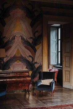 a living room with a piano, chair and wallpaper