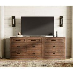 a flat screen tv sitting on top of a wooden dresser