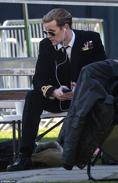 a man sitting on top of a bench wearing headphones