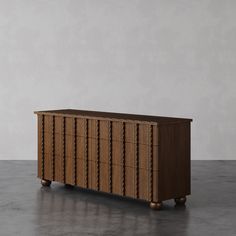 a large wooden cabinet sitting on top of a cement floor next to a white wall