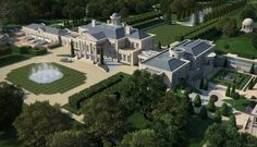 an aerial view of a large mansion with a fountain in the center and trees surrounding it