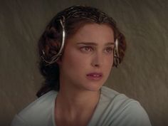 a woman with metal hair clips on her head looking at the camera while wearing a t - shirt