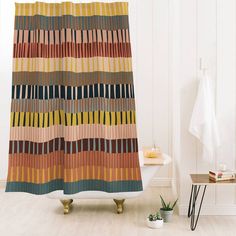 a bathroom with a bathtub, shower curtain and rug in the shape of stripes