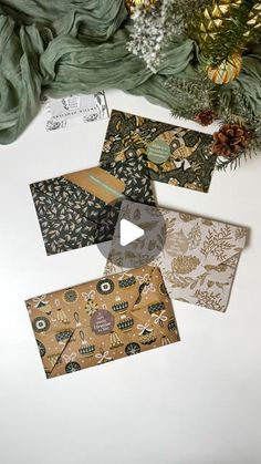 four different types of envelopes sitting on top of a white table next to a christmas tree