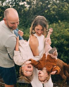 a man and woman holding two children in their arms