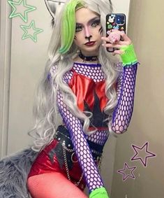 a woman with green hair is taking a selfie in front of a mirror wearing cat costume