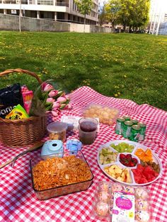 a picnic table with food and drinks on it in the middle of a grassy area