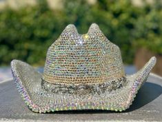 I am now offering custom bedazzled cowboy hats that sparkle beyond belief due to the high quality glass crystal rhinestones I use. I can make yours using a hat of your choice if you prefer to supply your own, or from a selection of 5 colors I have sourced that are good quality faux suede: White, ivory, Tan, Pink or Black.  They come in two sizes S/M or L/XL. These hats are made to last! They require almost 30 hours of meticulous labour. The brims are covered in rhinestones using permanent adhesive both upper and under sides for extra spectacular sparkle! I can source any color rhinestones, so feel free to message me about color choices or options. If you prefer a lower cost option that weighs a little less, I can use resin rhinestones instead, but I suggest the glass crystals for their sup Silver Hat With Rhinestones For Rodeo, Silver Rhinestone Hat For Rodeo, Bejeweled Cowboy Hat, Western Silver Hat With Rhinestones, Western Bling Hat For Rodeo, Western Hats With Bling For Rodeo, Western Style Bling Hats For Rodeo, Festival Hats With Rhinestones And High Crown, Festival Hat With Rhinestones And High Crown