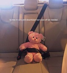 a teddy bear sitting in the back seat of a car