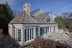 a house with a stone roof and white windows