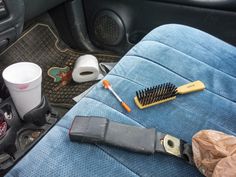 there is a brush, cup and other items in the back seat of a car