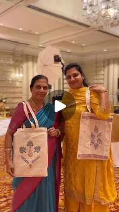 two women standing next to each other holding shopping bags