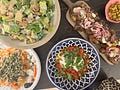 a table topped with lots of different types of food and plates filled with salads