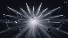 a black and white photo of a person standing in the middle of a light show