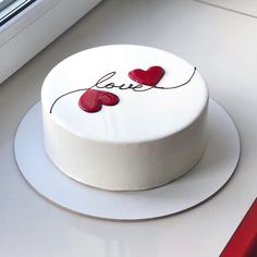 a white cake with red hearts on it