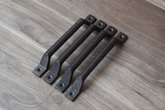 four black iron handles on a wooden floor