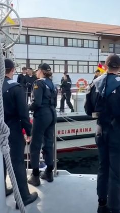 some people are standing on the deck of a boat and one is wearing a life jacket