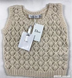 a white sweater with tags attached to it