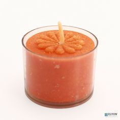 an orange candle with a wooden stick sticking out of it's center, on a white background