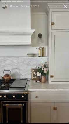 a stove top oven sitting inside of a kitchen next to white cabinets and counter tops