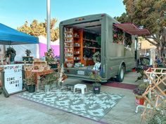 a truck parked in front of a store filled with potted plants and other items