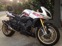 a white and black motorcycle parked in front of a building