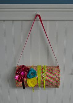 a roll of toilet paper hanging on a wall with ribbons and other items attached to it