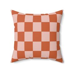 an orange and white checkerboard pillow on a white background with the words,