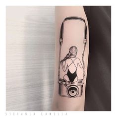 a woman with a camera tattoo on her arm