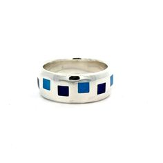 Indulge in the exquisite craftsmanship of our 8mm scroll ring with enamel accents. Handmade in either sterling silver or 14k yellow gold, this classic ring features an inlaid pattern of aqua blue and cobalt blue vitreous enamel squares. Perfect as a stand alone piece or to accent other pieces all ready in your collection. Specifications Material Sterling Silver 14k Yellow Gold Enamel Vitreous - Aqua Blue Vitreous - Cobalt Blue