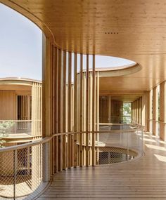 the inside of a building with wooden floors and columns on each side, along with circular balconies