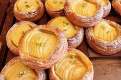 many pastries are sitting on a wooden tray