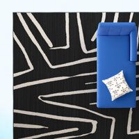 a blue case sitting on top of a black and white rug next to a pillow