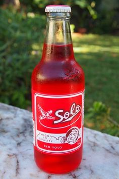 a red soda bottle sitting on top of a table