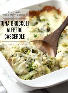 broccoli alfredo casserole in a white dish with a wooden serving spoon