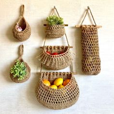 three baskets are hanging on the wall with fruits and vegetables in them as if they were made out of straw