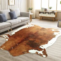 a living room with a couch, chair and cow hide rug